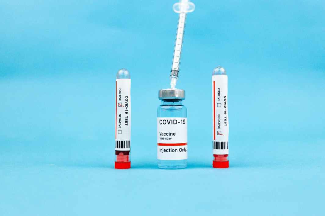 vaccine ampoule and test tubes on blue surface